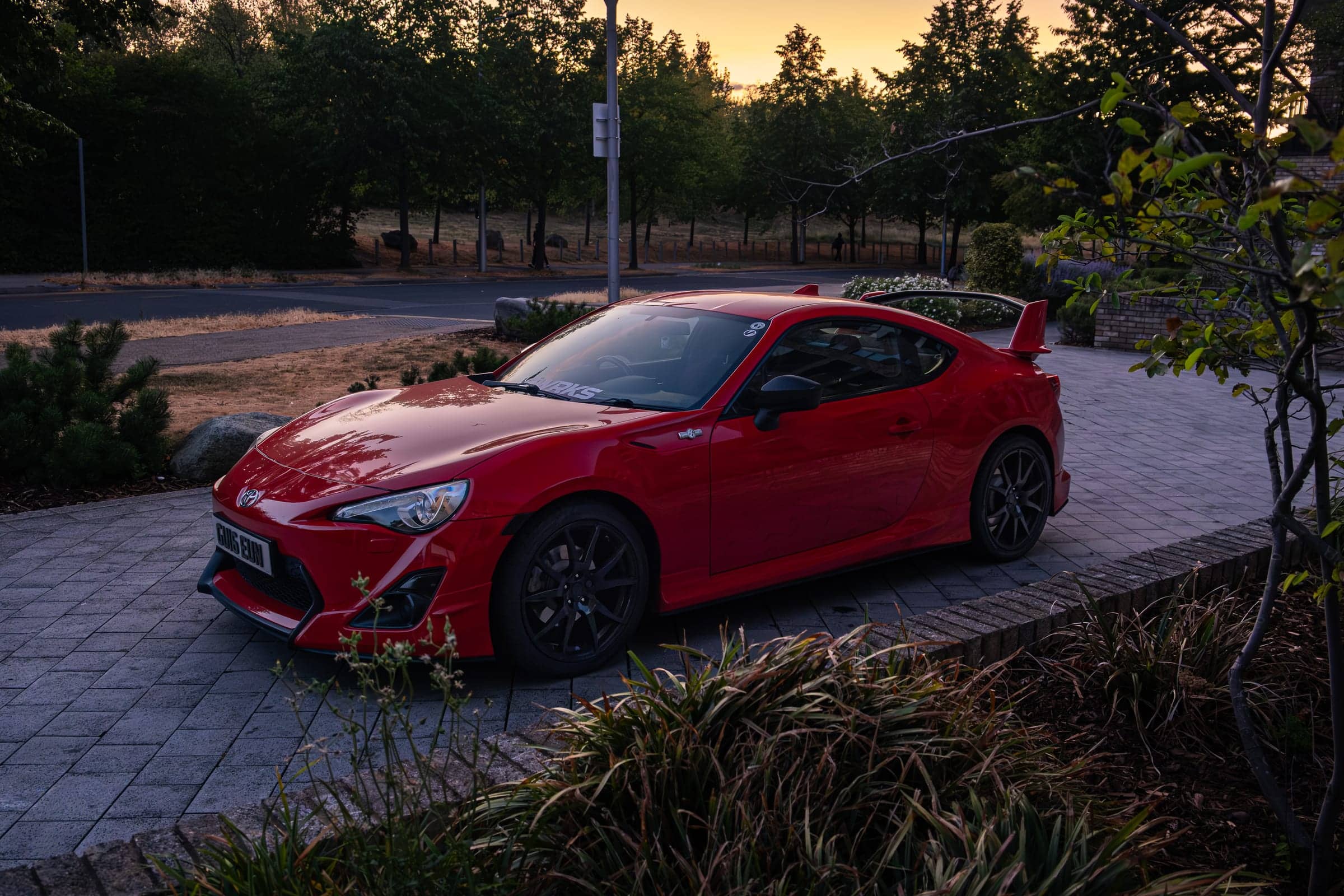 Red Toyota GT86 Aero, front three-quarter view at golden hour